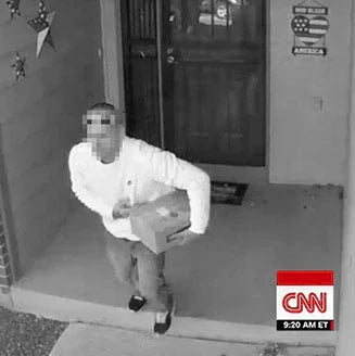 Person in white shirt holding package on porch, home security footage