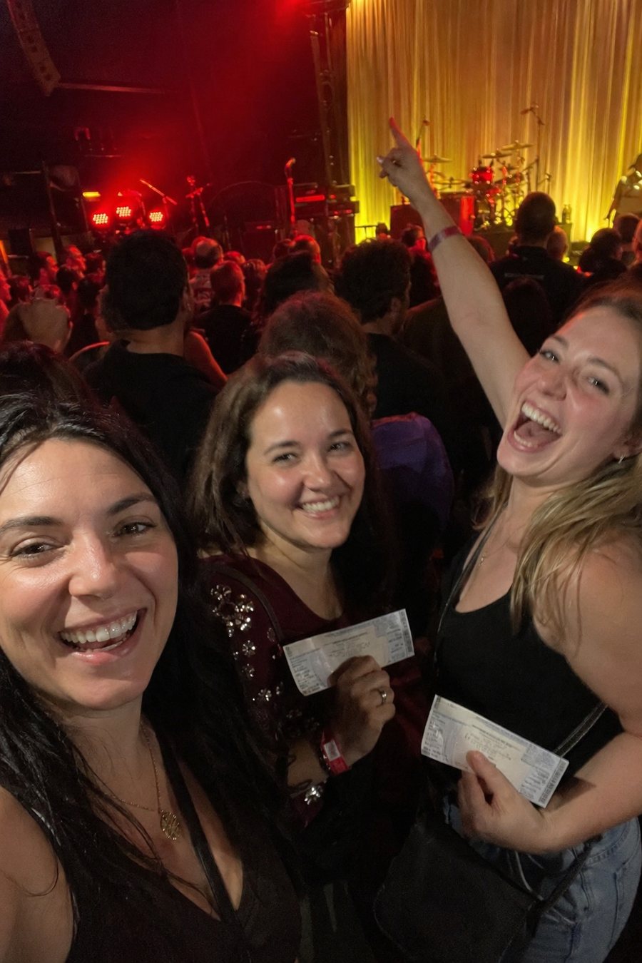 Friends laughing near a small concert stage